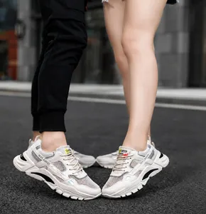Detailed view of breathable white mesh leisure sneakers worn by a couple on a street background