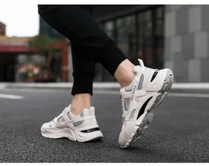 Detail of breathable white chunky men's sneakers shown in an outdoor walking pose.