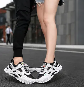 Macro view of stylish black and white breathable mesh chunky sneakers for couples on street