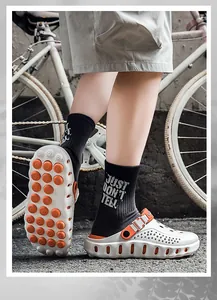 Detailansicht der weißen Herren-Clogs mit orangefarbener stoßdämpfender Sohle
