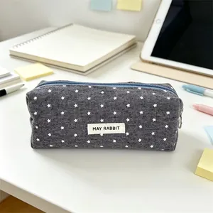 Dark gray pencil case with white stars and MAY RABBIT label on a desk
