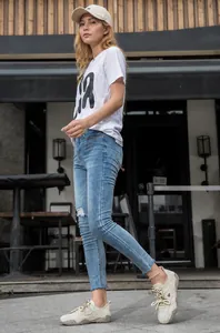 Close-up detail of women's leather casual sneakers worn in an outdoor street setting