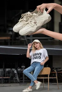 Lifestyle view of beige leather outdoor sneakers worn by a model in a street setting