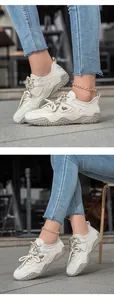 Detailed view of beige leather outdoor sneakers with rugged rubber soles and logo