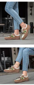 Detailed view of outdoor casual leather sneakers with green accents and unique textured soles
