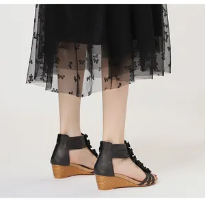 Elegant black bohemian wedge sandals featuring floral accents and wood-textured heel
