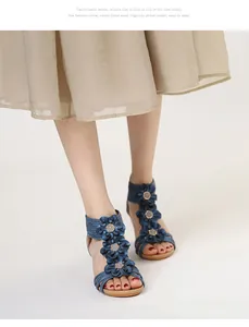 Close-up of blue Bohemian wedge sandals with floral decorations on feet, match skirt