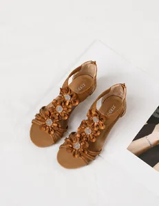 Detailed view of brown bohemian wedge sandals with floral rhinestone accents