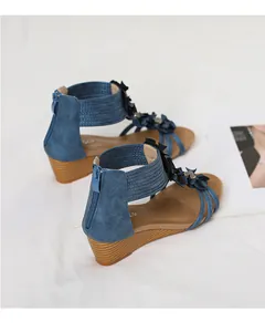 Detailed view of bohemian blue wedge sandals with floral accents and back zipper.