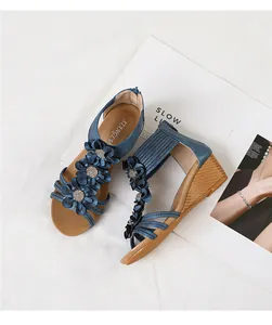 Close-up of bohemian blue wedge sandals featuring elegant 3D flower details and a zipper back.