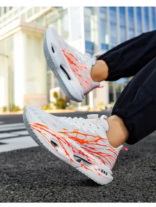 Detailed side view of white mesh running shoes with vibrant orange graphic prints