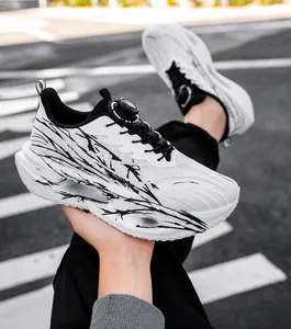 Detailed view of white mesh running shoes featuring a unique black splash pattern design