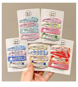 Set of colorful patterned BB hair clips for girls presented on white display cards