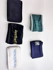 Detail view of multiple colored spa headbands with various embroidered custom logos.