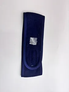 Close-up detail of navy blue terry cloth face wash headband with embroidered white leaf logo