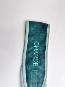 Macro detail of teal microfibre Velcro headband with CHARDE embroidery for makeup.