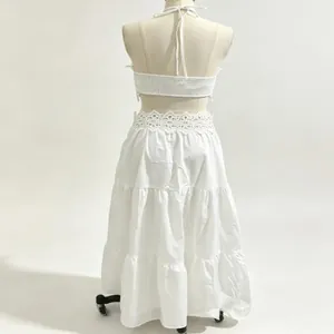 Vista posteriore di un set top a fascia con pizzo bianco e gonna lunga a balze