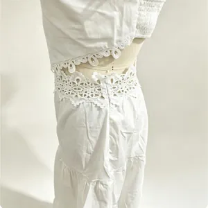 Dettaglio ravvicinato della vita in pizzo bianco su gonna a balze e set crop top