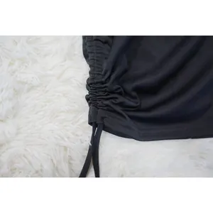 Close-up detail of adjustable drawstring ruching on a black mini dress