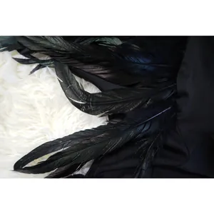 Detailed macro shot of high-quality black feather trim on an elegant off-shoulder dress