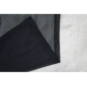 Close-up of black semi-transparent mesh fabric with fine stitching detail on white fur.