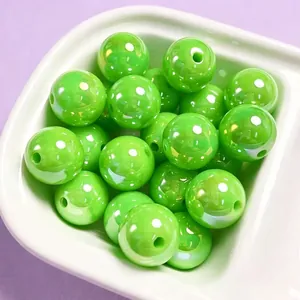 Close-up of 16mm glossy lime green acrylic beads for DIY jewelry making in a white bowl