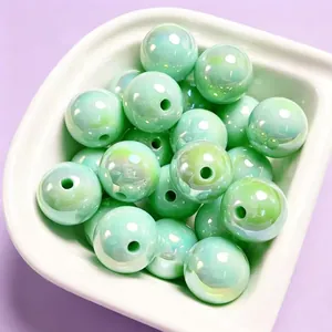 Detailed view of 16mm mint green iridescent UV electroplated acrylic beads in a white bowl