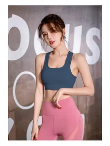 Volledig zicht van een fitnessmodel met een marineblauwe sportbeha en roze legging in de gym
