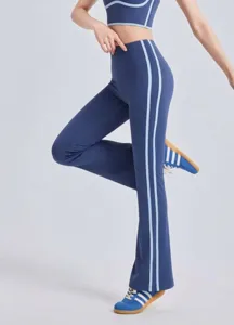 Detail view of blue flared yoga pants with light blue side stripes on model.