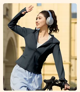 Asiatisches Model trägt eine schmale, winddichte Fleece-Yogajacke beim Radfahren im Freien.