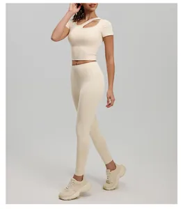 Side profile detail of cream asymmetrical yoga top with cutout design and matching leggings.