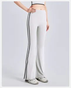 Close-up detail view of white high-waisted yoga flare pants with black side stripes
