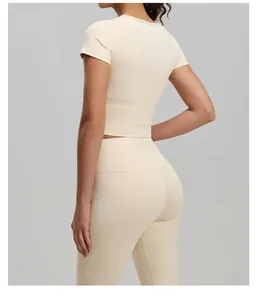 Detailed back view of a beige short-sleeve yoga top with high-waist athletic leggings