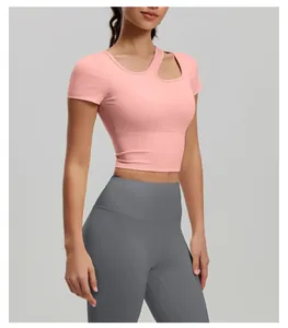 Detailed view of pink asymmetric high-stretch yoga short sleeve top with chest pads on model