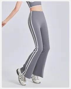 Detailed visual of grey high-waisted flared yoga pants featuring sporty side stripes