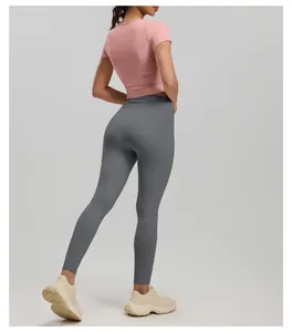 Back view of a pink slim-fit yoga short sleeve paired with grey high-waist leggings.