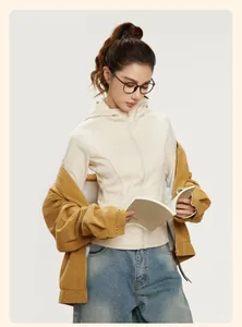 Asiatisches Model in einer beigen Yoga-Jacke und Cordjacke beim Lesen, Lifestyle-Aufnahme