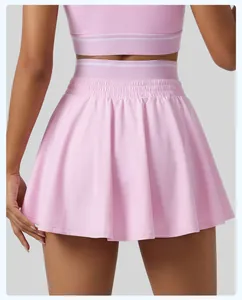 Vue détaillée d'une jupe de tennis rose à taille haute avec un design à double ceinture.
