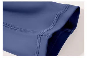Gros plan des coutures plates sur le poignet d'un haut de yoga bleu aux manches longues