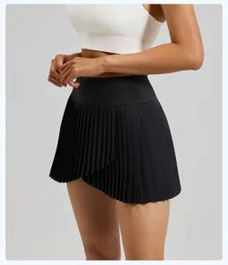 Detail view of black pleated sports skort with asymmetric overlapping design and slim fit.