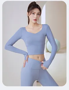 Model wearing a light blue long-sleeve yoga set with V-neck cross design detail.