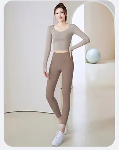 Full body shot of a woman wearing a slim fit khaki yoga top and brown fitness leggings