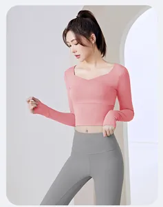 Detail view of slim fit pink long sleeve yoga top and gray leggings set for fitness.