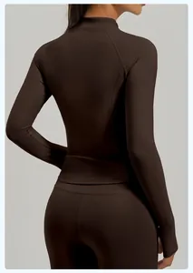 Vista trasera de una chaqueta de yoga marrón ajustada y leggings a juego en una modelo.