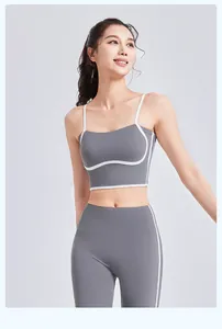 Detailopname van een model dat een grijze yogaset draagt met witte biezen en taille