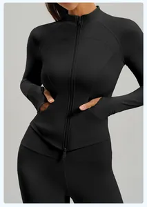 Detalle de chaqueta de yoga negra con cremallera doble y bolsillos laterales funcionales.