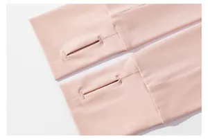 Détail des poignets d'une veste de protection solaire rose avec des passe-pouces