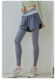 Primo piano di leggings sportivi grigi 2 in 1 con fascia in vita color block verde chiaro