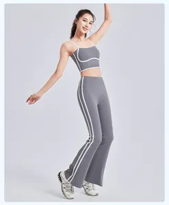 Detailopname van grijze yogaset met flared broek en witte streepaccenten voor sporten.