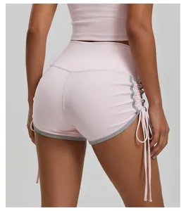 Dettaglio dei pantaloncini sportivi rosa a vita alta con coulisse laterale e bordo grigio